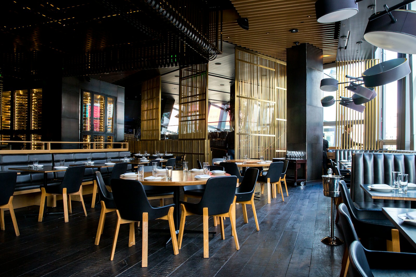 An authentic restaurant dining room with warm timber tables and natural greenery